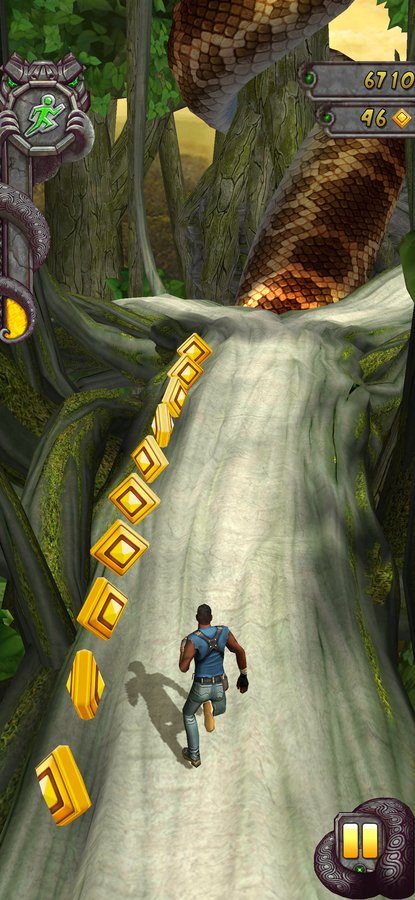 Temple Run 2 gameplay sliding down a jungle tree root collecting coins